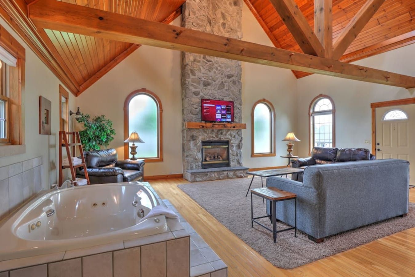 Indoor jacuzzi and stone fireplace inside a romantic Premier cottage for two in Berlin, Ohio