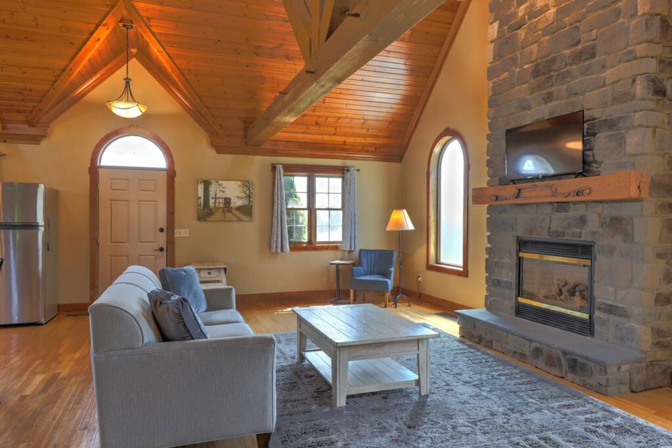 Vaulted living room with stone fireplace inside Premier Cottage #2 at Premier Cottages, Berlin Ohio