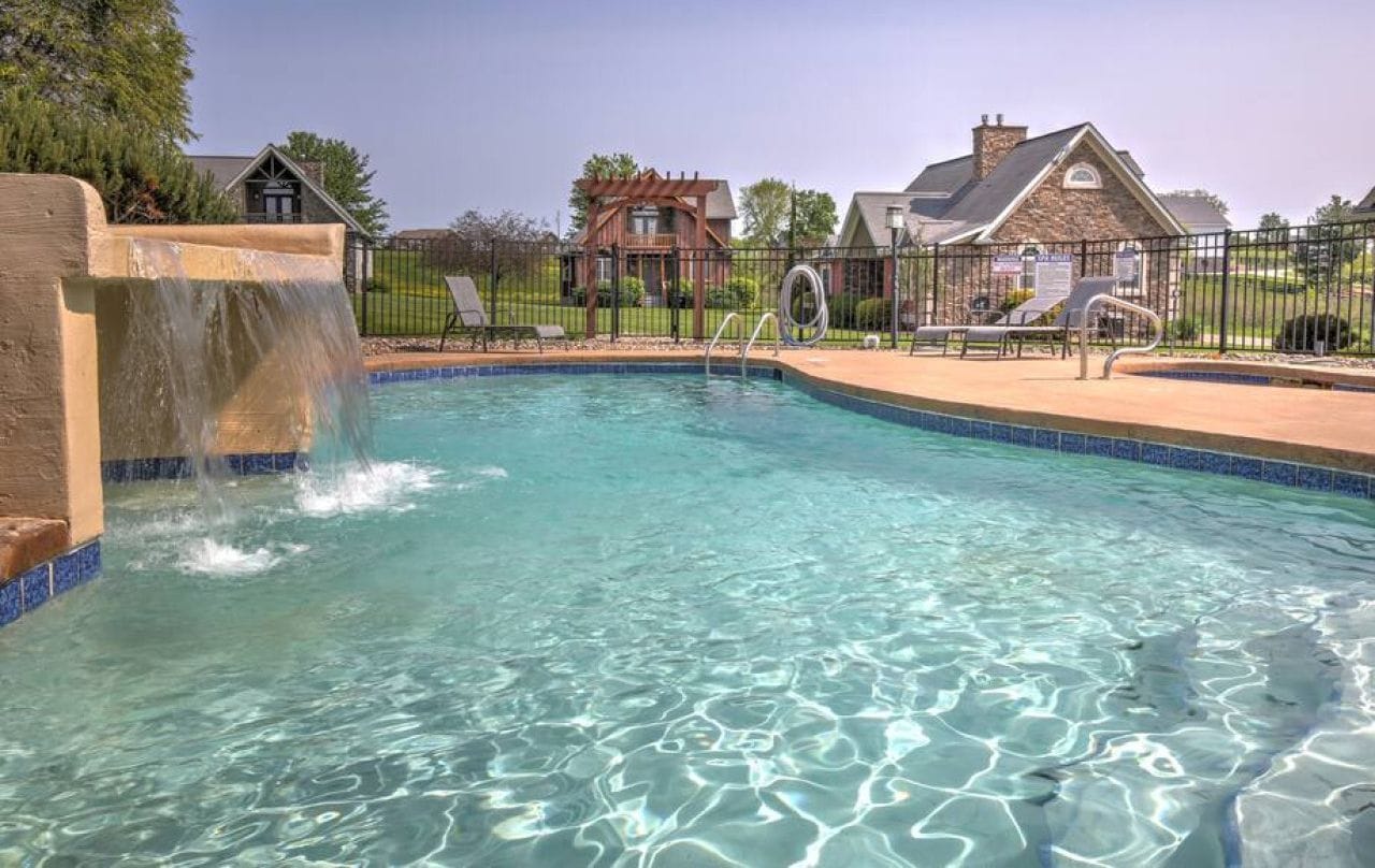 The resort-style pool with a waterfall and lounge chairs at Premier Cottages in Berlin, Ohio