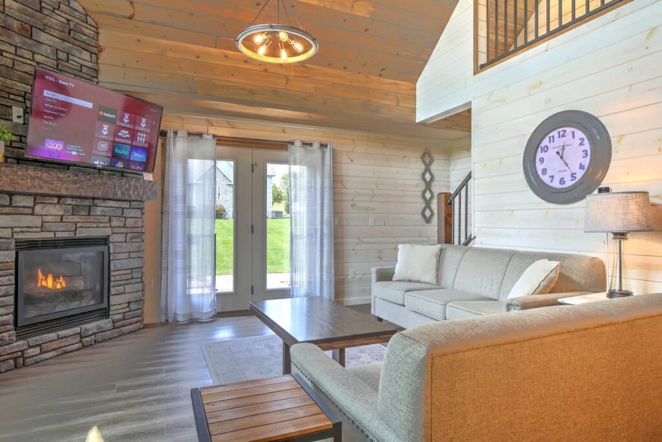 Bright modern living room with stone fireplace inside Premier Cottage #9, Berlin Ohio